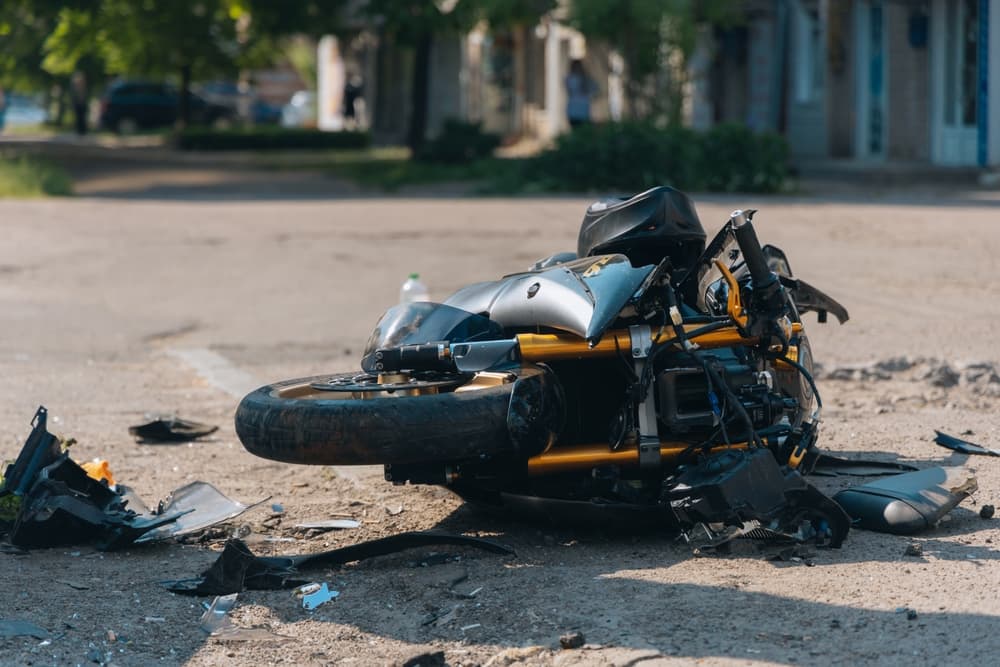 Smashed motorcycle laying on the road